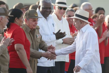 Cuba's President Raul Castro shakes hands with Cuba's Vice President and 2nd Secretary of Cuba's Communist Party Jose Ramon Machado Ventura during the ceremony marking the 64th anniversary of the July 26, 1953 rebel assault which former Cuban leader Fidel Castro led on the Moncada army barracks, Pinar del Rio, Cuba, July 26, 2017. REUTERS/Alexandre Meneghini