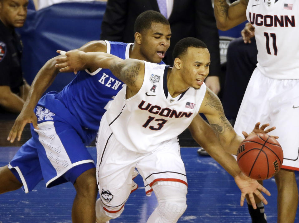 Connecticut guard Shabazz Napier (13) tries to control the ball as Kentucky guard Aaron Harrison (2) defends during the second half of the NCAA Final Four tournament college basketball championship game Monday, April 7, 2014, in Arlington, Texas. (AP Photo/Tony Gutierrez)