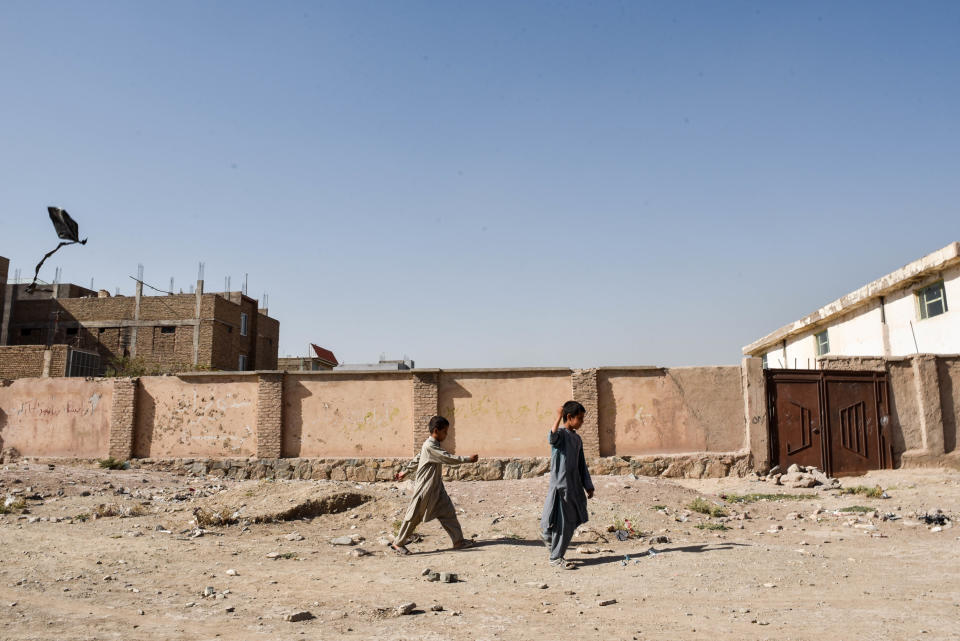 Two Afghan children play with a kite on the outskirts of Herat, where infrastructure like paved roads become more rare.