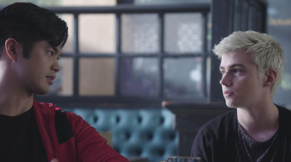 Alex Standall and Zach Dempsey stare at each other as they sit together at a restaurant table