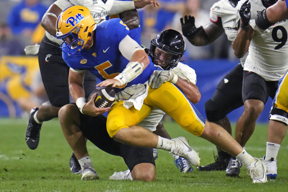 Pittsburgh quarterback Phil Jurkovec (5) is sacked by Cincinnati linebacker Jack Dingle, center, during the second half of an NCAA college football game in Pittsburgh on Saturday, Sept. 9, 2023. (AP Photo/Gene J. Puskar)