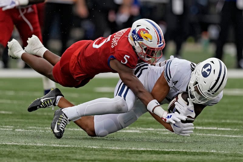 BYU wide receiver Keanu Hill is tackled by Kansas safety O.J. Burroughs.