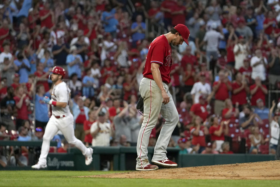 St. Louis Cardinals' Corey Dickerson, left, rounds the bases after hitting a two-run home run off Philadelphia Phillies starting pitcher Aaron Nola, right, during the seventh inning of a baseball game Monday, July 11, 2022, in St. Louis. (AP Photo/Jeff Roberson)