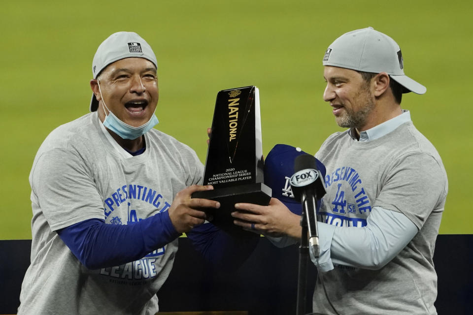 El manager de los Dodgers de Los Ángeles Dave Roberts (izquierda) y el presidente de operaciones de béisbol Andrew Friedman con el trofeo de campeones de la Liga Nacional tras vencer a los Bravos de Atlanta, el domingo 18 de octubre de 2020, en Arlington, Texas. (AP Foto/Eric Gay)