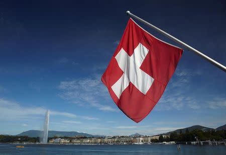 FILE PHOTO: A Swiss flag is pictured next to the Jet d'Eau (water fountain), and the Lake Leman from the St-Pierre Cathedrale in Geneva, Switzerland, June 5, 2012. REUTERS/Denis Balibouse/File Photo