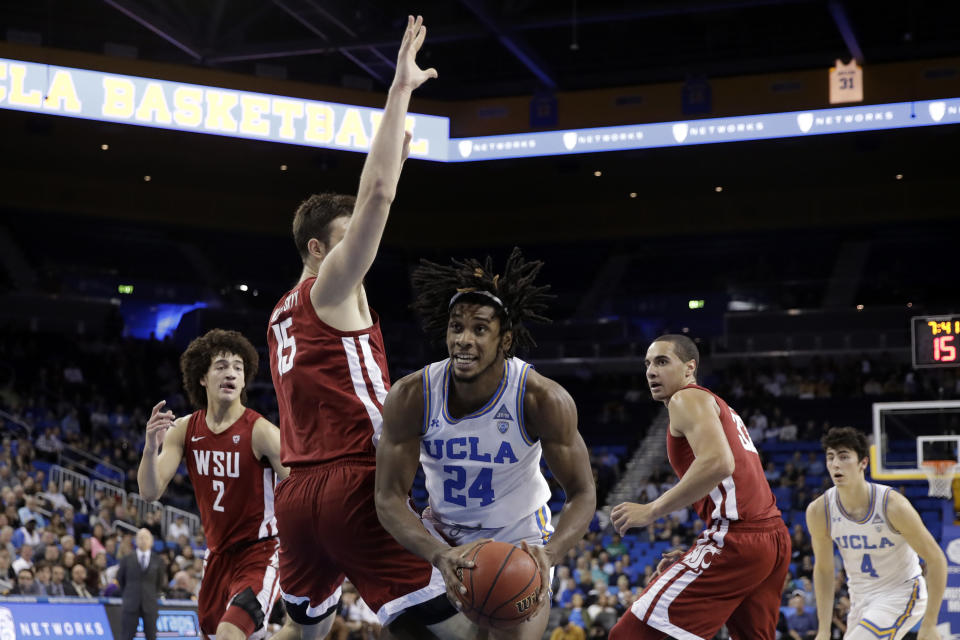 UCLA forward Jalen Hill (24) is defended by Washington State center Volodymyr Markovetskyy (15) during the first half of an NCAA college basketball game Thursday, Feb. 13, 2020, in Los Angeles. (AP Photo/Marcio Jose Sanchez)