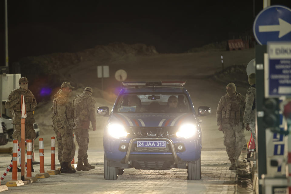 Turkish military and Gendarmery personnel stand at the entrance of the Copler gold mine near Ilic village, eastern Turkey, Tuesday, Feb. 13, 2024. A huge landslide hit a gold mine in eastern Turkey on Tuesday, trapping at least nine workers underground, officials said. (Ugur Yildirim/Dia images via AP)