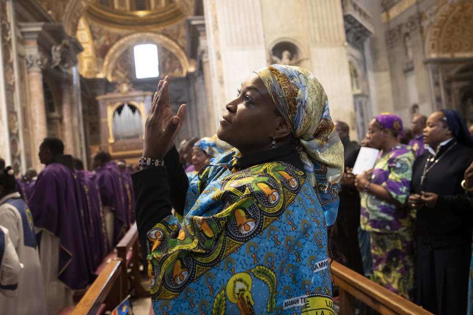 A woman prays during a Mass celebrated by Pope Francis for the Congolese community of Rome, in St. Peter's Basilica at the Vatican Sunday, Dec. 1, 2019. (AP Photo/Alessandra Tarantino)