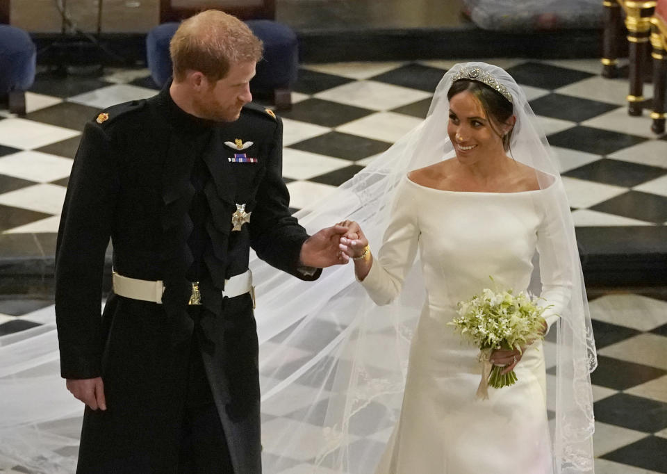 Britain's Prince Harry, Duke of Sussex (L) and Britain's Meghan Markle, Duchess of Sussex, (R) walk away from the High Altar toward the West Door to exit at the end of their wedding ceremony in St George's Chapel, Windsor Castle, in Windsor, on May 19, 2018. (Photo by Owen Humphreys / POOL / AFP)        (Photo credit should read OWEN HUMPHREYS/AFP via Getty Images)