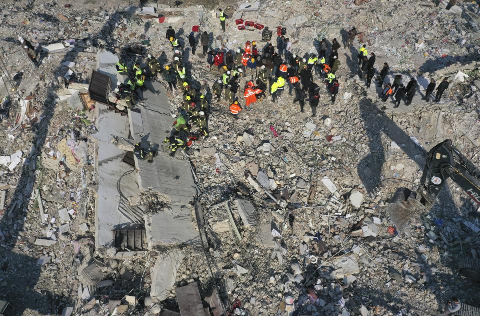 Rescue teams search for people in a destroyed building in Antakya, southeastern Turkey, Friday, Feb. 10, 2023. Rescuers pulled several earthquake survivors from the shattered remnants of buildings Friday, including some who lasted more than 100 hours trapped under crushed concrete after the disaster slammed Turkey and Syria. (AP Photo/Hussein Malla)