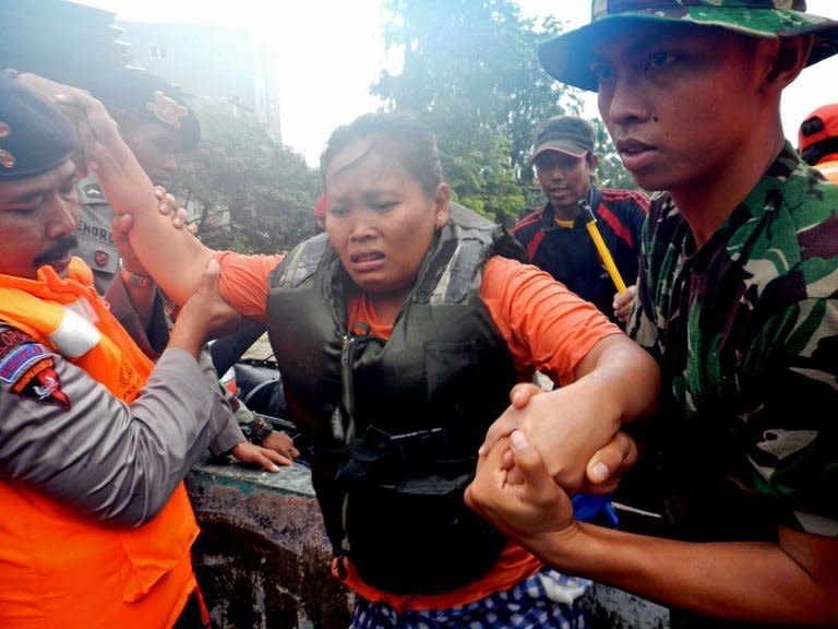 Indonesian military evacuate a woman from a flooded area in Jakarta, on January 18, 2013. The death toll from floods in Indonesia's capital has risen to 15 after rescuers found another four bodies, a police spokesman said on Saturday as floodwaters receded