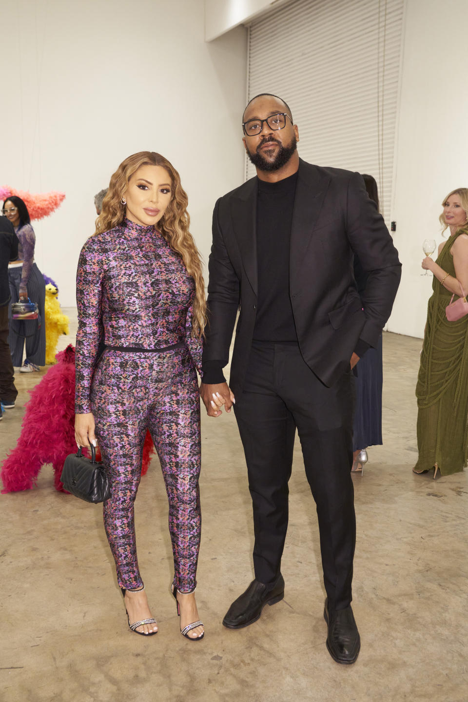 The couple  holding hands at an event