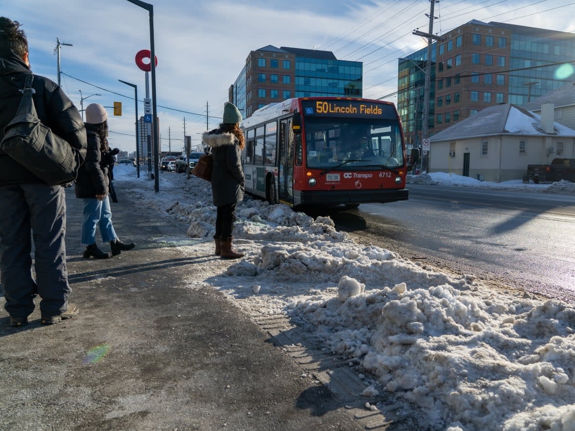 Passengers wait for a bus at Tunney's Pasture station last winter, when ridership remained far below pre-pandemic levels. (Francis Ferland/CBC - image credit)