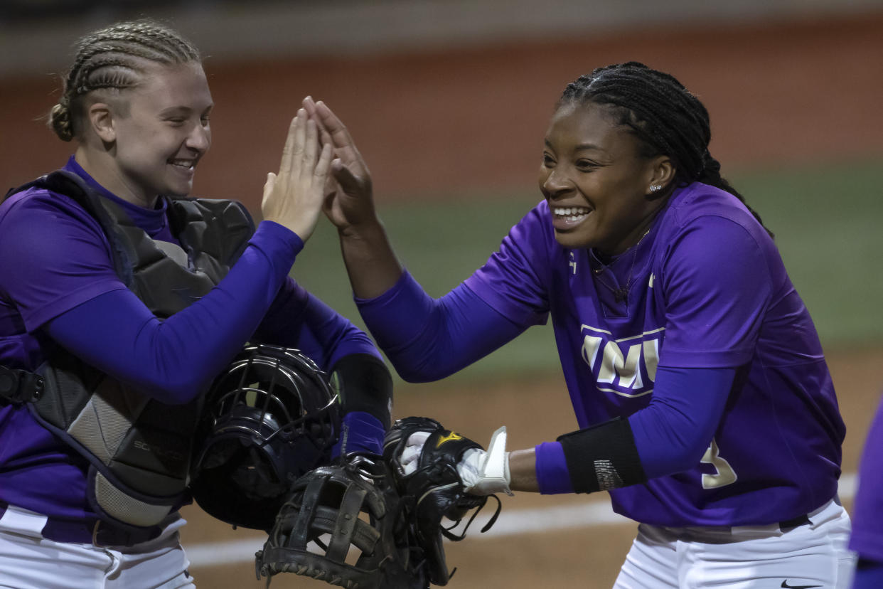 James Madison catcher Lauren Bernett (left) and pitcher Odicci Alexander celebrate a victory over Missouri in 2021. (AP Photo/Colin E. Braley)