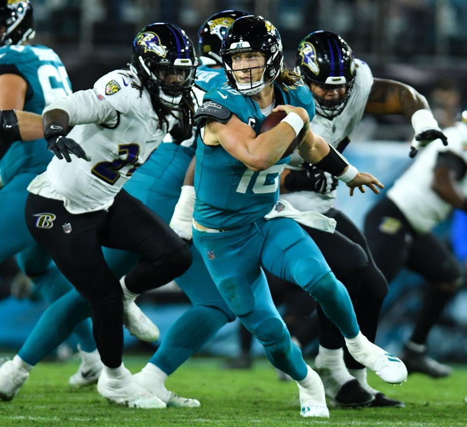 Jaguars quarterback Trevor Lawrence (16) scrambles for a first down against the Ravens.