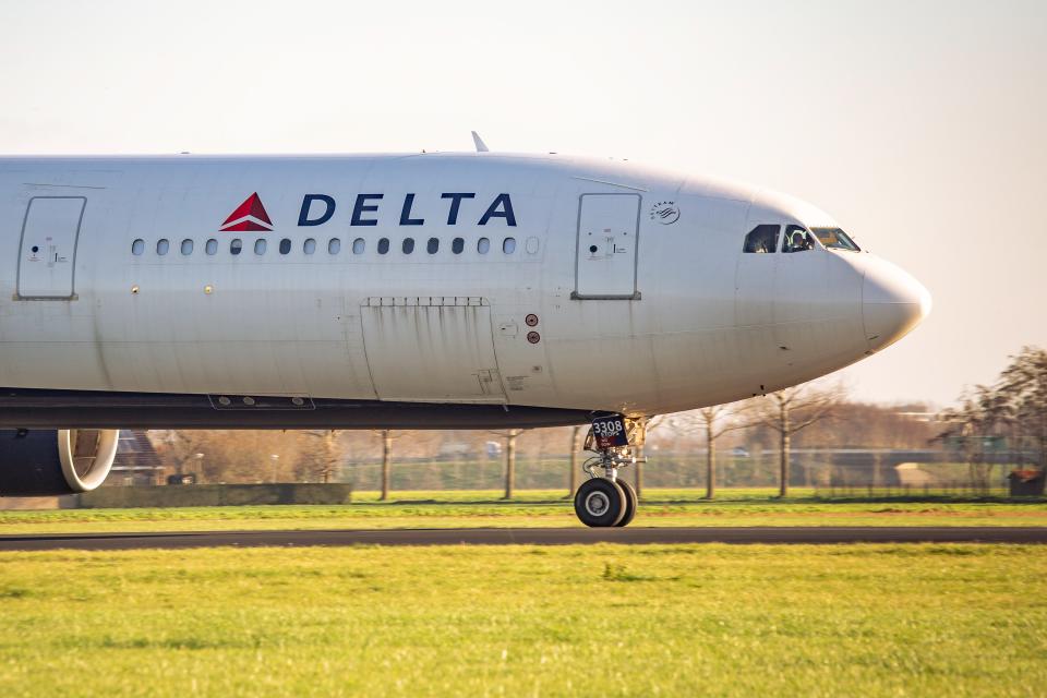 The front part of a Delta Airlines A330 taxiing on the runway after touching down at Amsterdam Schiphol Airport
