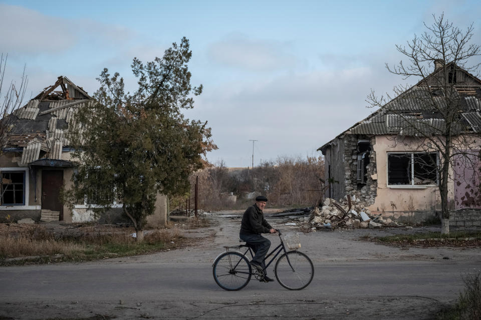 A local resident rides a bike near destroyed houses, amid Russia's attack on Ukraine, in the village of Arkhanhelske, Kherson region, Ukraine November 8, 2022. REUTERS/Viacheslav Ratynskyi     TPX IMAGES OF THE DAY