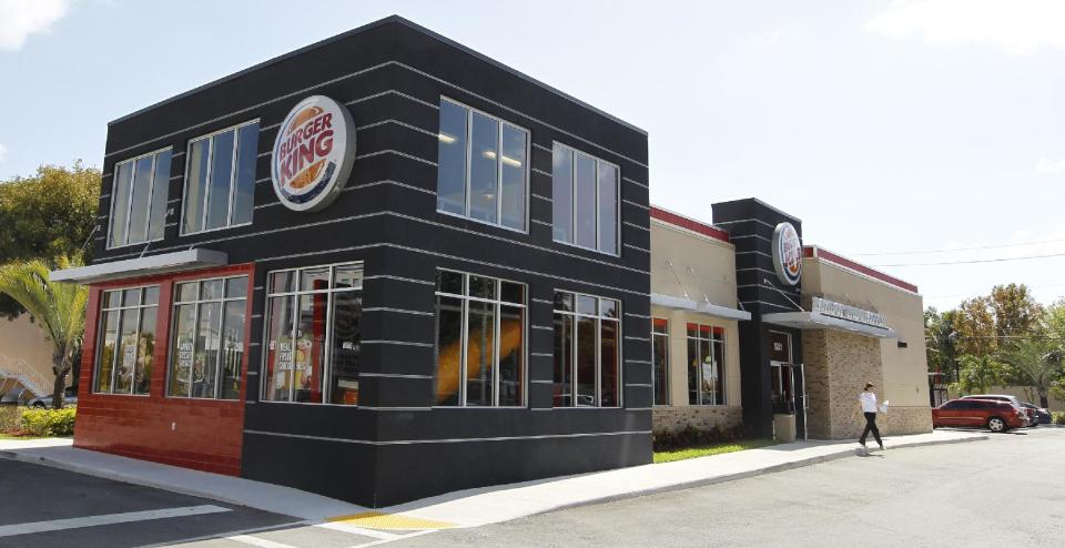 In this March 28, 2012 photo, a patron leaves a Burger King restaurant in Miami. On Monday, April 2, 2012, Burger King launches 10 menu items including smoothies, frappes, specialty salads and snack wraps in a star-studded TV ad campaign. It's the biggest menu expansion since the chain opened its doors in 1954. (AP Photo/Luis M. Alvarez)