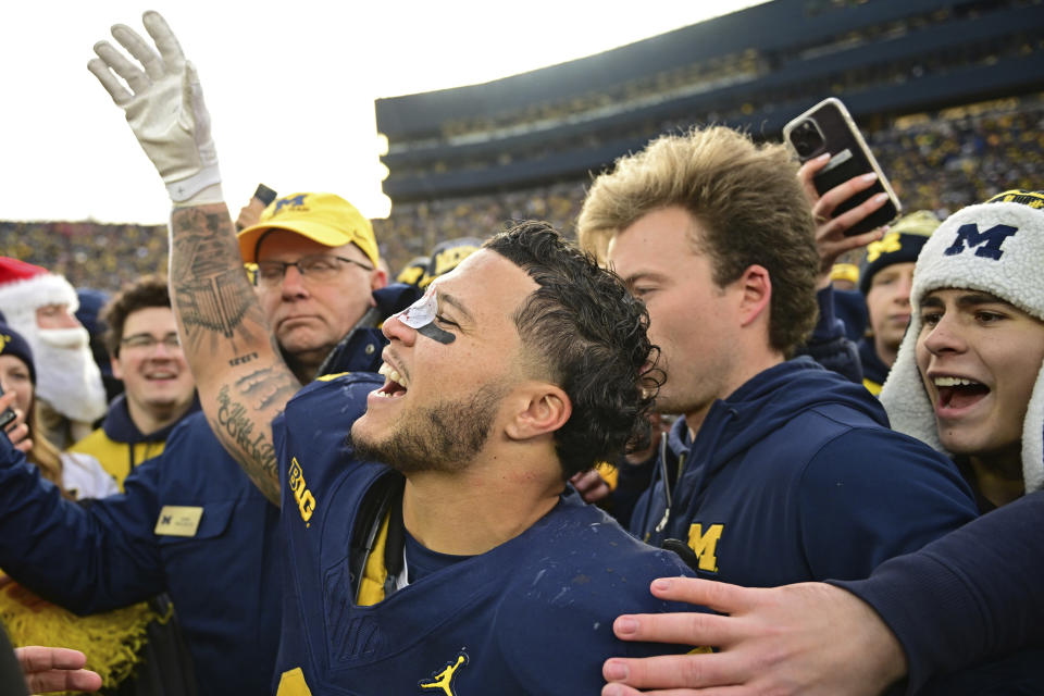 Michigan running back Blake Corum celebrates with fans after Michigan defeated Ohio State 30-24 in an NCAA college football game, Saturday, Nov. 25, 2023, in Ann Arbor, Mich. (AP Photo/David Dermer)