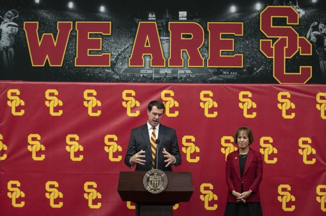 USC athletic director Mike Bohn speaks while standing next to USC President Carol Folt.