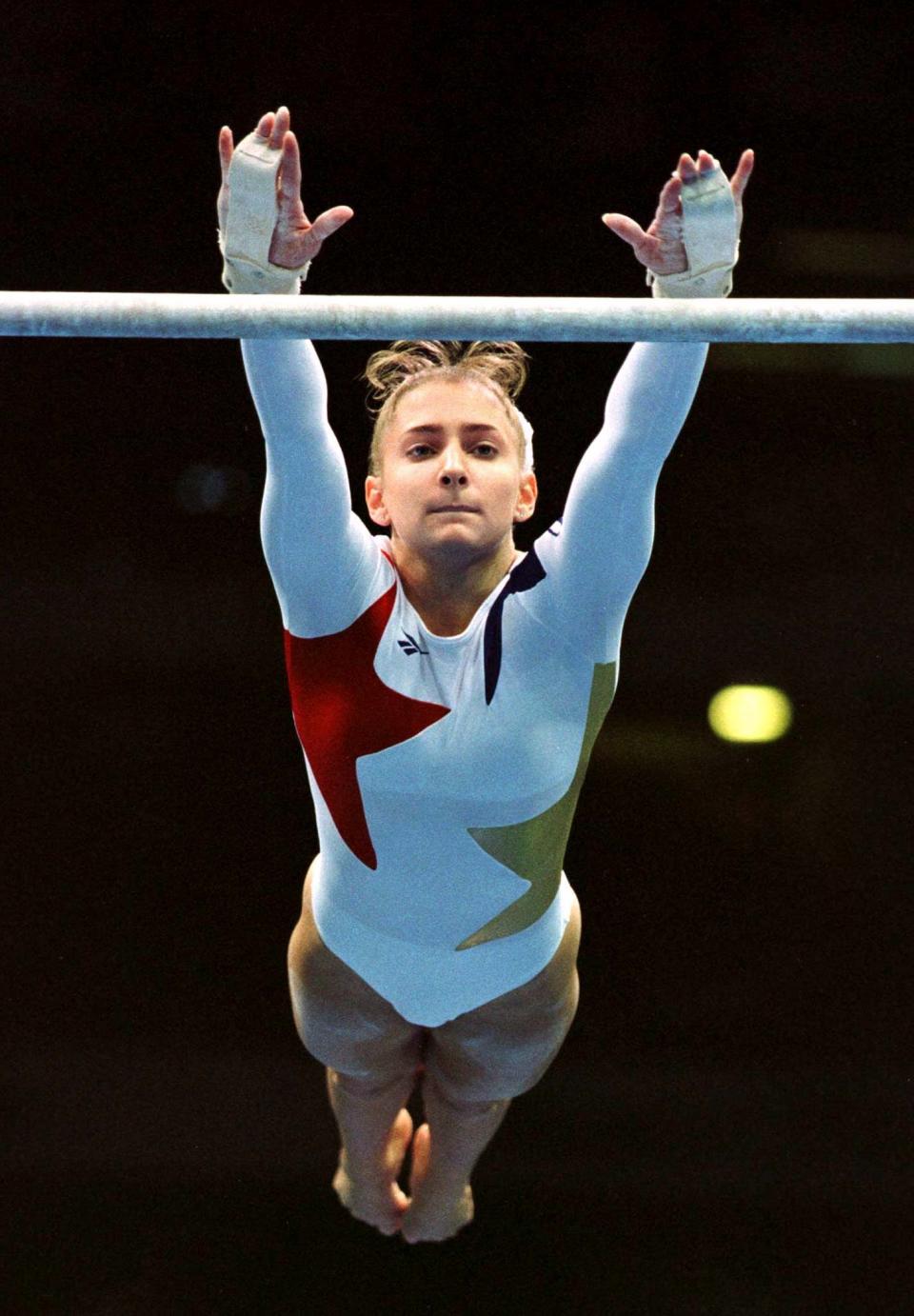 United States gymnast Shannon Miller reaches for the uneven bar during the individual all-around finals July 25, 1996 during the summer Olympics in Atlanta. (Mike Blake / Reuters)