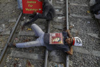 Demonstrators with placards lie on the railway tracks in an attempt to disrupt train service during a protest against the military coup in Mandalay, Myanmar on Wednesday, Feb. 17, 2021. Demonstrators in Myanmar gathered Wednesday in their largest numbers so far to protest the military’s seizure of power, even after a U.N. human rights expert warned that troops being brought to Yangon and elsewhere could signal the prospect of major violence. (AP Photo)