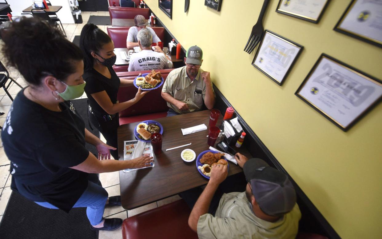 Janette Caruso, left, and Kayla Hubble bring food out to a table at Shirley's Diner in Leland, N.C., Tuesday, Aug. 17, 2021. The longtime restaurant has been in Leland since 1979 and has a devoted following.