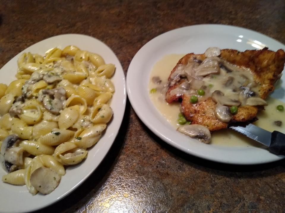 Chicken Palermo is a breaded chicken breast topped with a lemon wine sauce with cheese, peas and fresh mushrooms. At left is a side of Grandma's shells.