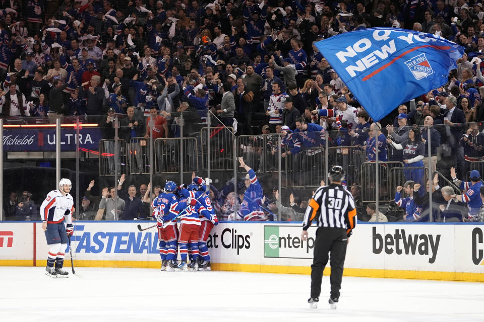 Washington Capitals' Nic Dowd, left, skates past the New York Rangers as they celebrate a goal by Mika Zibanejad during the first period in Game 2 of an NHL hockey Stanley Cup first-round playoff series, Tuesday, April 23, 2024, in New York. (AP Photo/Frank Franklin II)