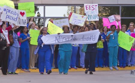 Staff members of Texas Health Presbyterian Hospital gather outside the emergency room to show support for fellow nurse Nina Pham, in Dallas, Texas October 16, 2014. REUTERS/Jaime R. Carrero