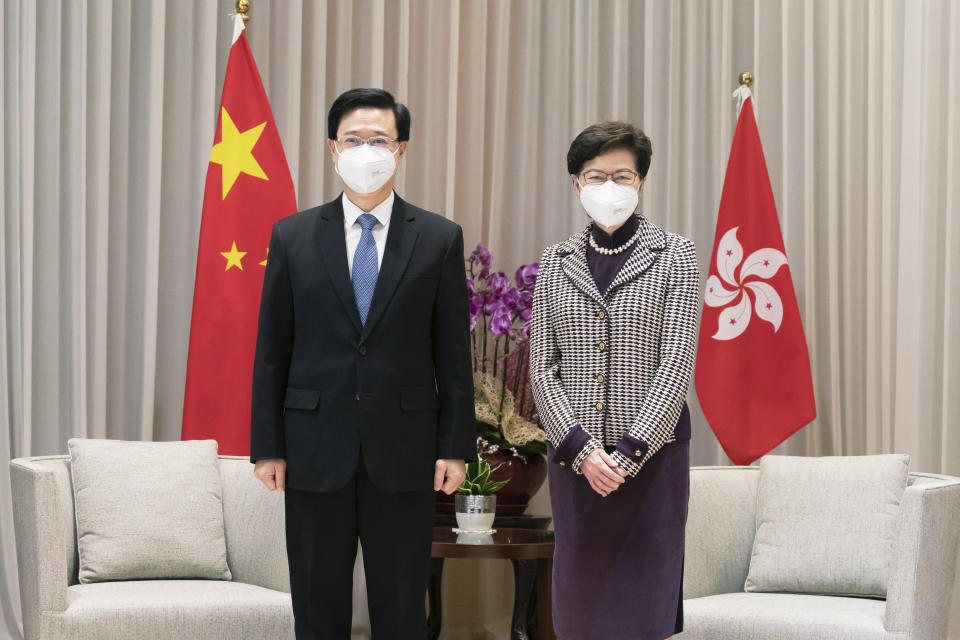 El presidente electo de Hong Kong, John Lee (izquierda), y la presidenta saliente, Carrie Lam, posan para una foto durante una reunión en el complejo del Gobierno Central en Hong Kong, el lunes 9 de mayo de 2022. (Anthony Kwan/Foto de Pool vía AP)