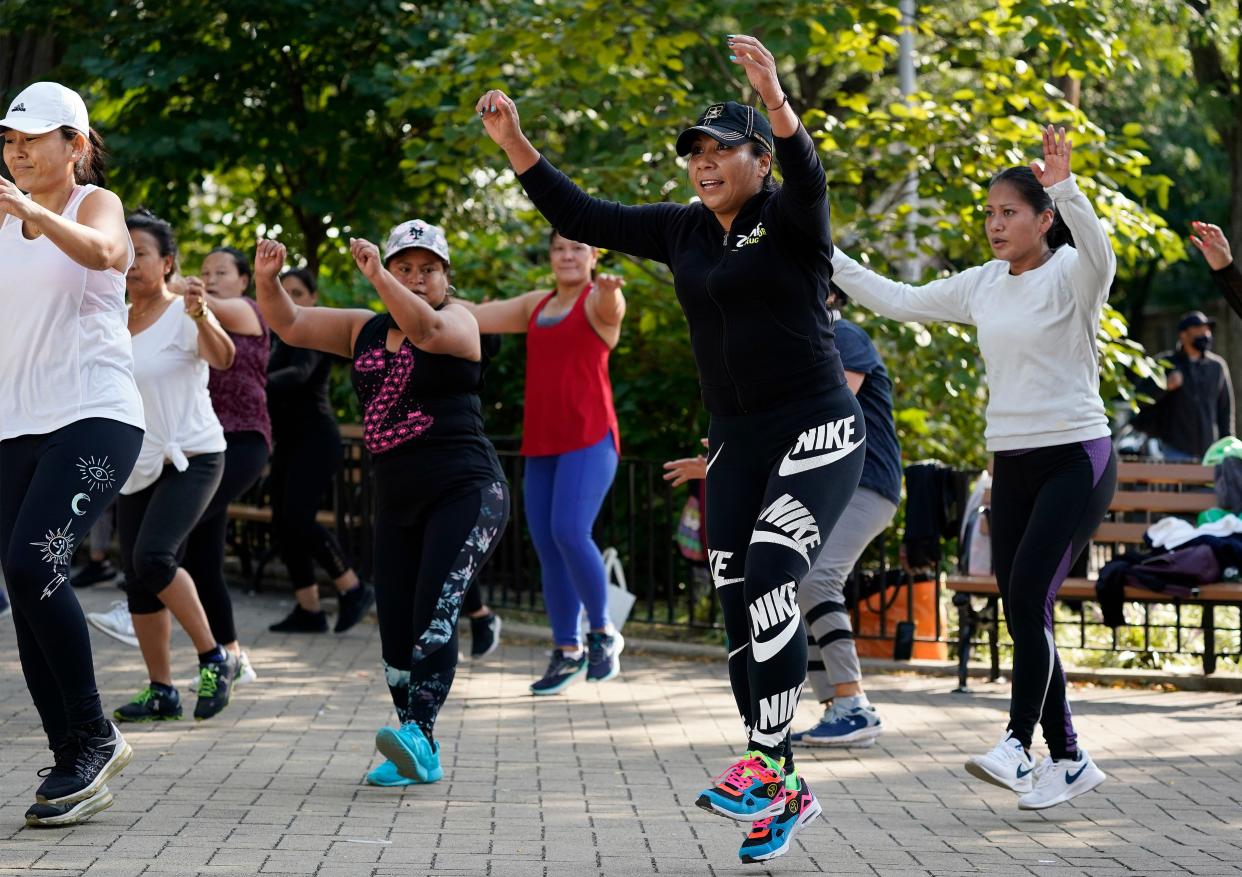 Yeni Salazar, center, leads a Zumba class in Queen's Elmhurst Memorial Park on Monday, Sept. 21, 2020, in New York. Salazar has been leading the morning outdoor classes since May because the COVID-19 pandemic has closed her health club.