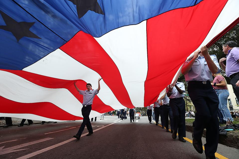 Air Force JROTC members march with a giant American Flag as they move along Liberty Street during the annual Veterans Day Parade in Savannah.