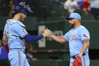 Texas Rangers catcher Jonah Heim, left, celebrates with relief pitcher Kirby Yates, right, after a win over the Cincinnati Reds in a baseball game Sunday, April 28, 2024, in Arlington, Texas. (AP Photo/Richard W. Rodriguez)