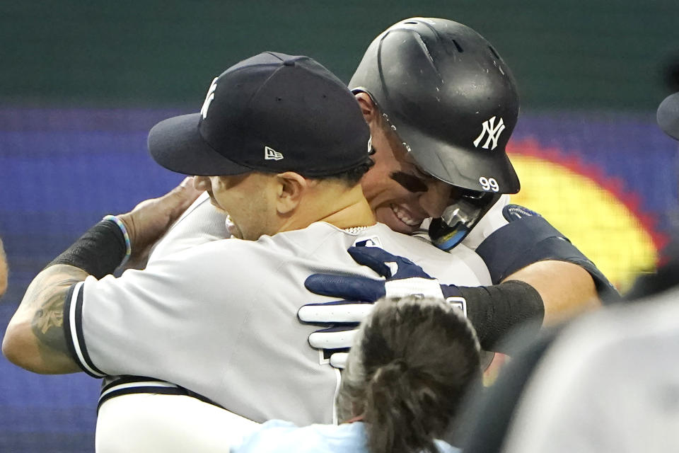 Aaron Judge (derecha), de los Yanquis de Nueva York, es felicitado tras conectar su 62do jonrón de la temporada, con el que rompió el récord de Roger Maris, el martes 4 de octubre de 2022, ante los Rangers de Texas (AP Foto/LM Otero)