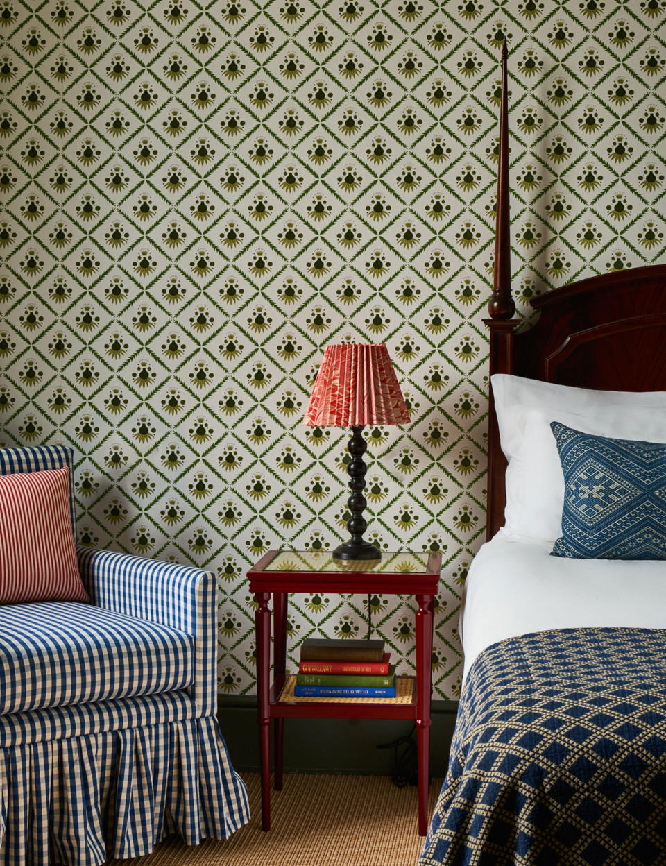 Small bedroom with green pattern wallpaper and chair