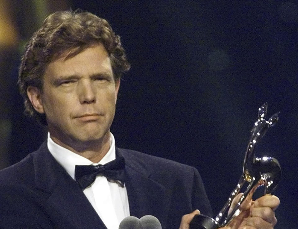 FILE- Dutch media entrepreneur John de Mol holds his "Bambi" media award during the awarding ceremony in Berlin on Friday evening, Dec. 8, 2000. De Mol, the former producer of Dutch talent show "The Voice of Holland" apologized Thursday Jan. 20, 2022, after allegations of sexually inappropriate conduct linked to the ratings blockbuster were aired. Police and prosecutors called reports of the alleged abuse "disturbing" and urged victims to come forward with their experiences. (Wolfgang Kumm/Pool Photo via AP, File)