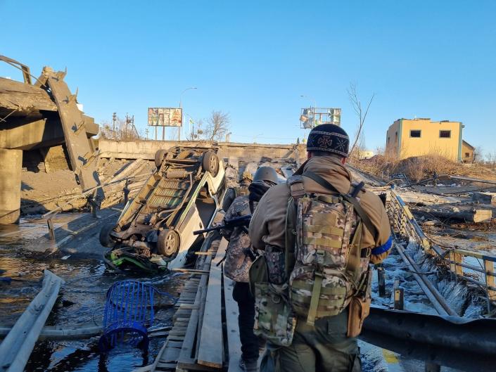 A Foreign Legion fighter looks on at wreckage in Ukraine following a Russian attack.