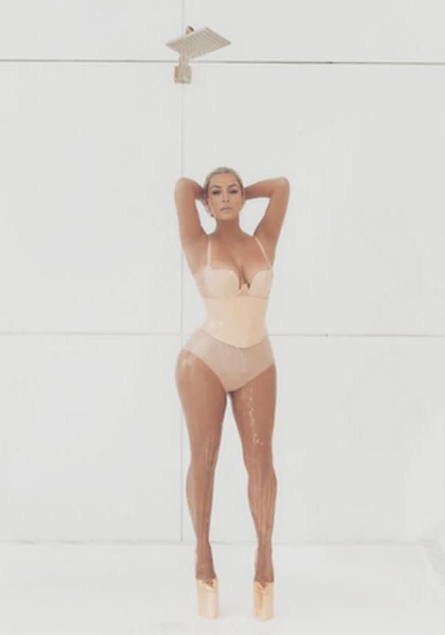 In the video Kim showers in milk in a tight nude-coloured swimsuit.