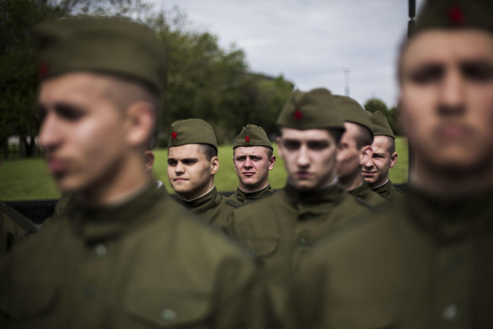 Young Ukrainian men make a formation wearing the Red Army uniform from WWII during the commemoration of Victory Day in Donetsk, Ukraine, Friday, May 9, 2014. Victory Day honors the armed forces and the millions who died in World War II. This year it comes as Russia is locked in the worst crisis with the West, over Ukraine, since the end of the Cold War. (AP Photo/Manu Brabo)