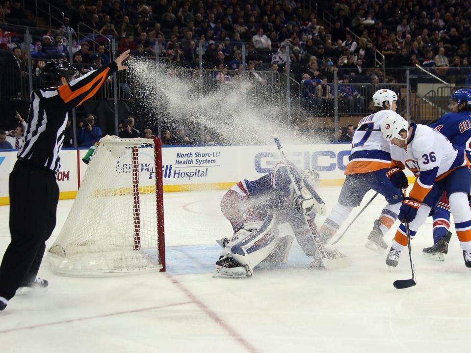 Eric Boulton #36 of the New York Islanders receives a two minute penalty for unsportsmanlike conduct for spraying Henrik Lundqvist #30 of the New York Rangers with ice at Madison Square Garden on December 20, 2013