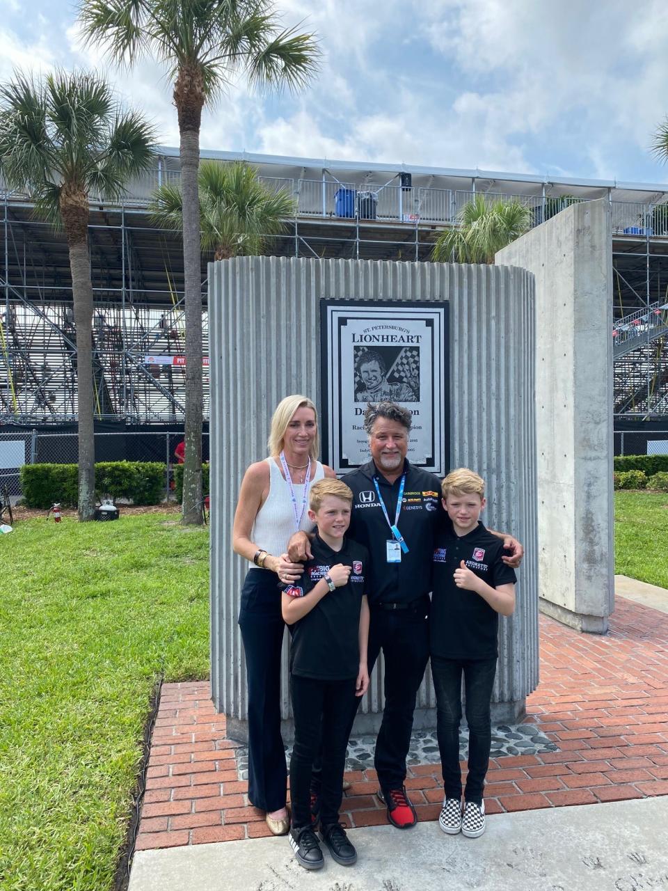 Susie Wheldon and her sons Sebastian and Oliver pose with Michael Andretti at the Dan Wheldon Memorial as the boys were announced as developmental drivers for Andretti's race team.