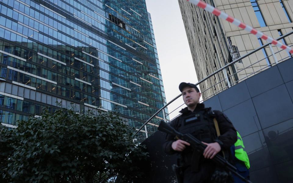 A security officer stands guard near a damaged office building in the Moscow City following a drone attack