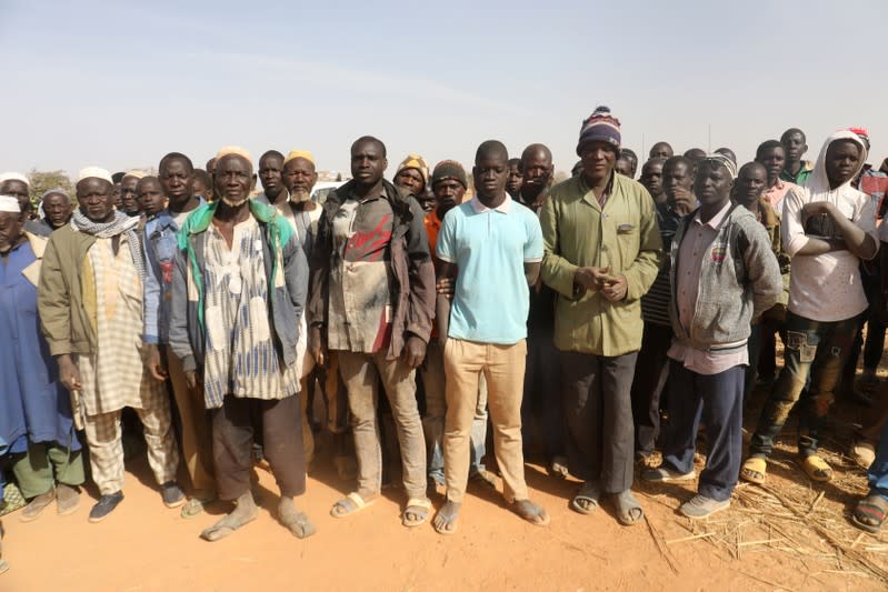 Displaced people wait for help at a village in Dablo area