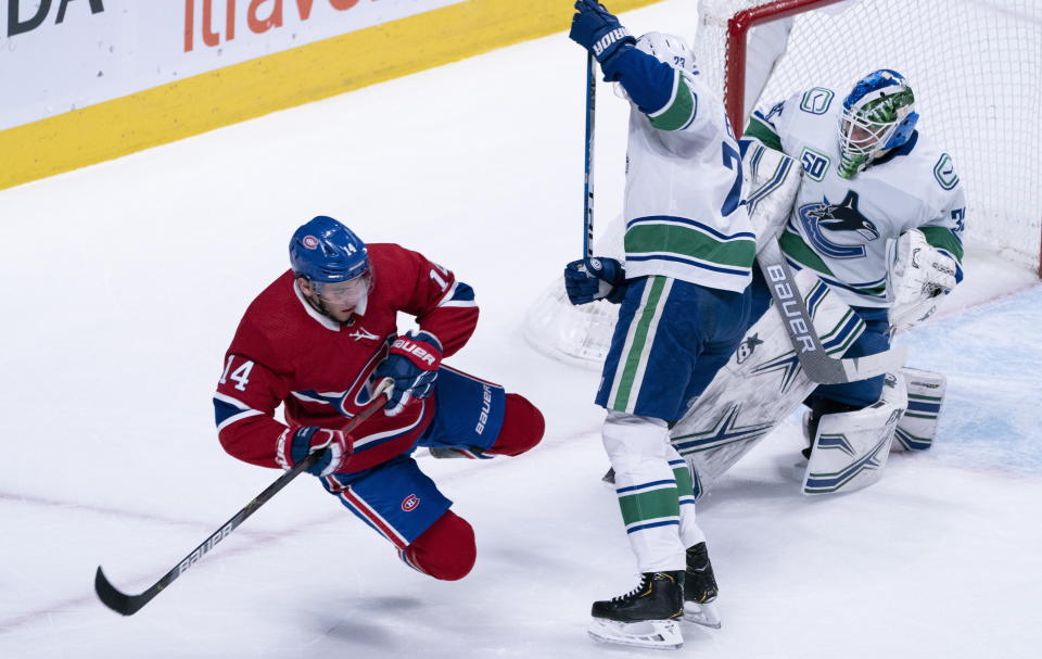 Montreal Canadiens' Nick Suzuki is taken out from in front of Vancouver Canucks goaltender Thatcher Demko by defenseman Alexander Edler during the first period of an NHL hockey game Tuesday, Feb. 25, 2020, in Montreal. (Paul Chiasson/The Canadian Press via AP)