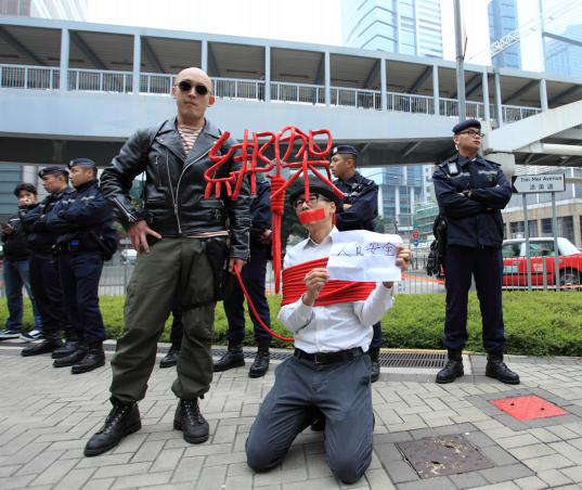 香港運動人士黃國才以行動劇抗議銅鑼灣書店股東桂民海等人遭中國當局綁架囚禁。（圖/Freedom to Write Index 2019）