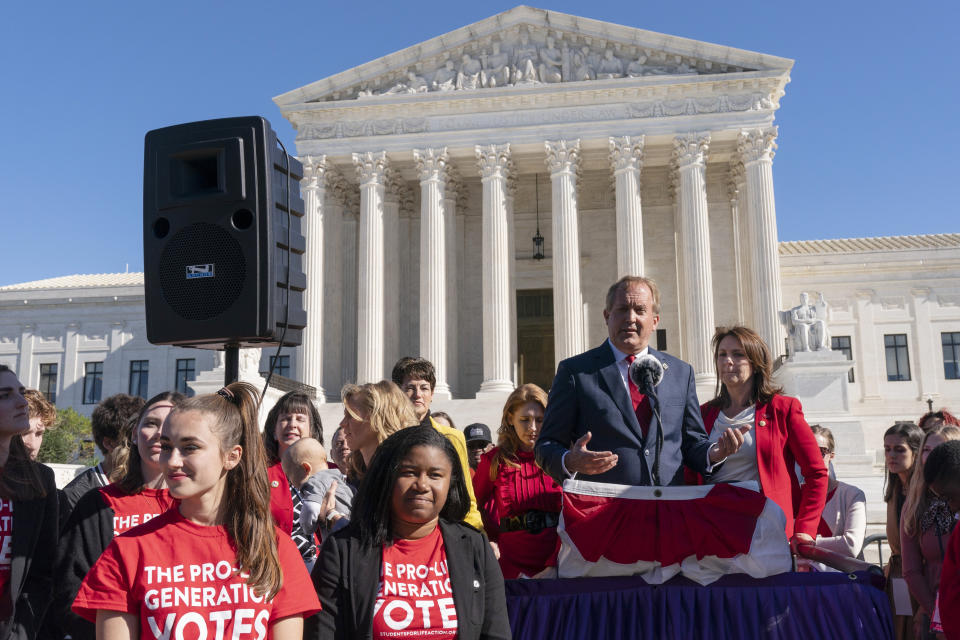 Texas Attorney General Ken Paxton addresses anti-abortion activists at a rally outside the Supreme Court, Monday, Nov. 1, 2021, on Capitol Hill in Washington, after hearing arguments on abortion in the court, as his wife and Texas State Sen. Angela Paxton, stands right. (AP Photo/Jacquelyn Martin)