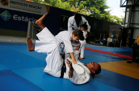 Judo athlete Yolande Bukasa, a refugee from Democratic Republic of Congo, performs with a kid during a news conference where she was announced as part of the refugee athletes qualified for the 2016 Rio Olympics in Rio de Janeiro, Brazil, June 3, 2016. REUTERS/Pilar Olivares/Files