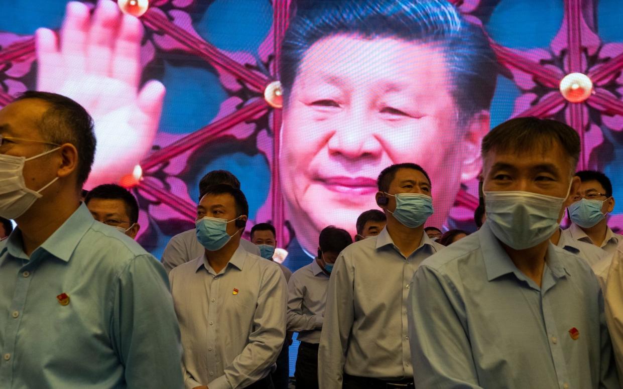 SHANGHAI, CHINA - JUNE 17: Visitors stand inside the Memorial of the First National Congress of the Communist Party of China, as Chinese President Xi Jinping is seen on the screen in the back, on June 17, 2021 in Shanghai, China. The memorial, built where the first congress of the party was started before being interrupted by authorities in 1921, is considered, together with Nanhu Red Boat in Jiaxing, the physical birthplace of the CPC and it is one of the key sites of the so called "Red Tourism". - Andrea Verdelli/Getty Images