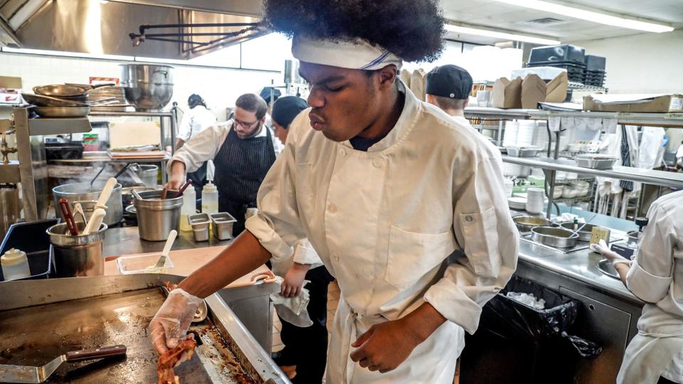 Line chef Jamar King keeps lunch orders moving at the Colonial Dining Room, a student-run restaurant at Newport Area Career and Technical Center at Rogers High School.